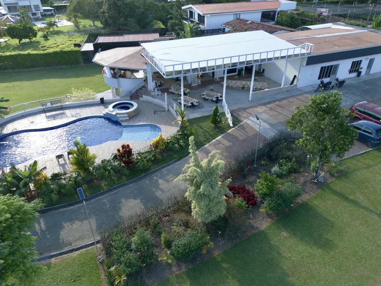 Vista aérea de la piscina, los jardines y el salón social de Finca El Rosal Combia